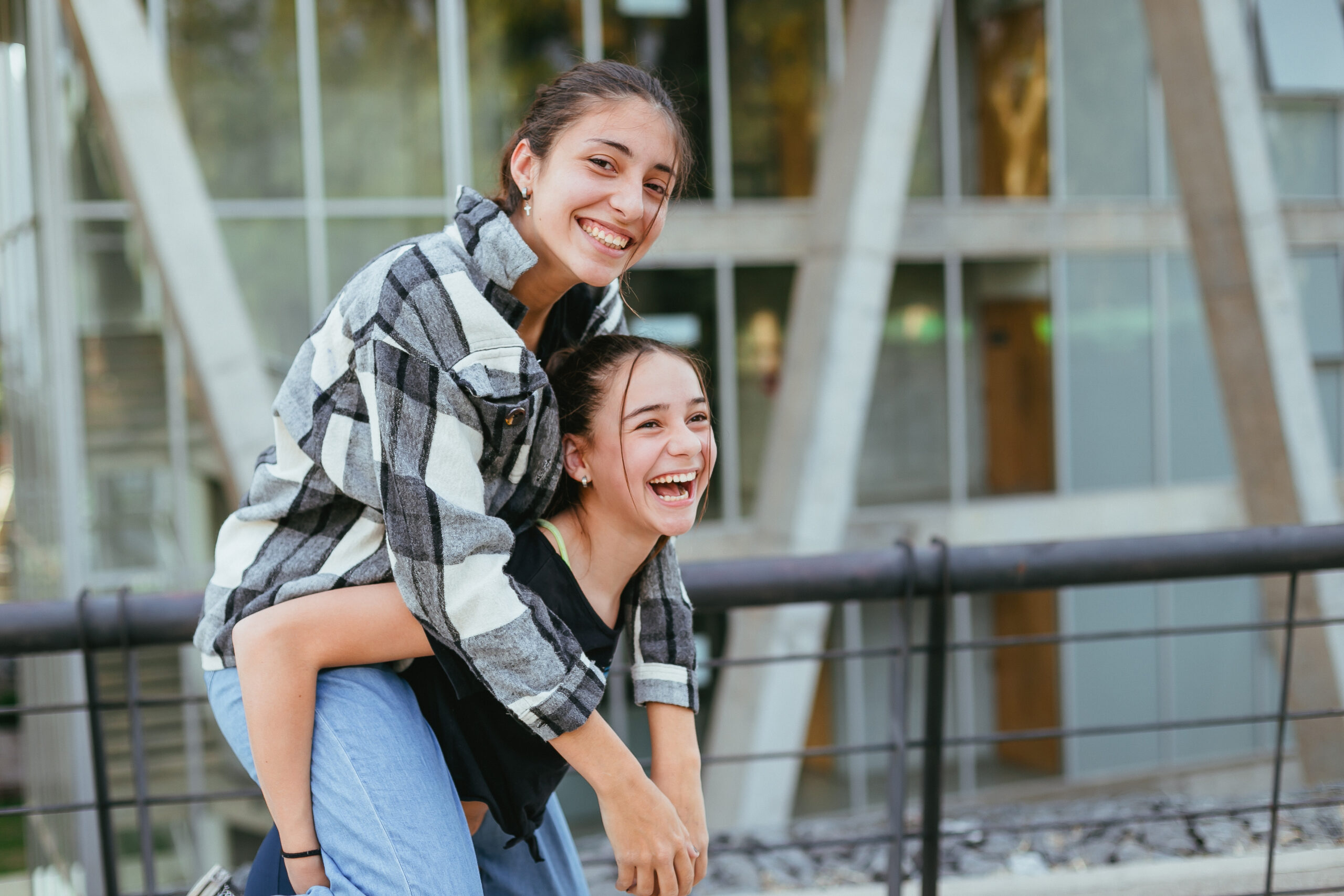 two teenage sisters in the city laughing and having a good time Sisters outside playing together in Mesquite, TX