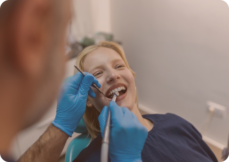 Woman in dental chair getting her teeth cleaned in Mesquite, TX.
