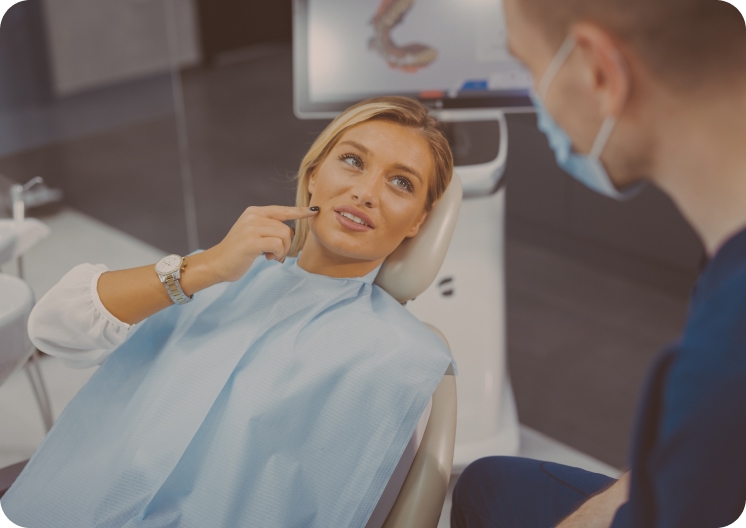 Lady showing her dentist where her tooth pain is located